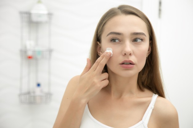 Jovem mulher bonita usando anti-aging
