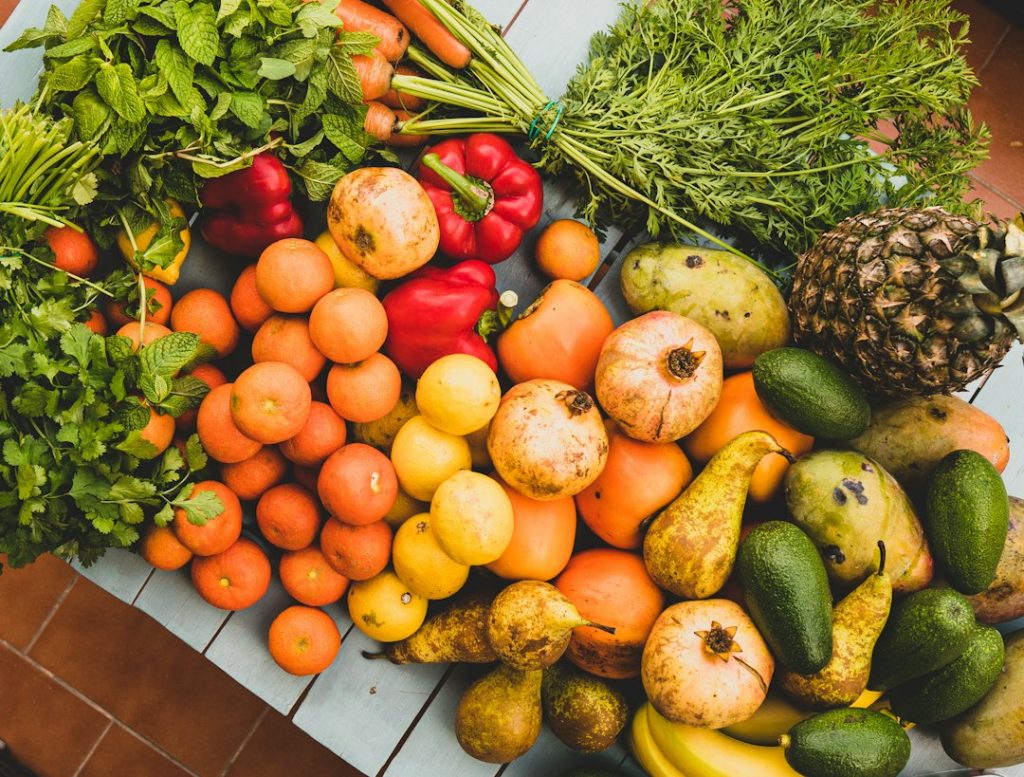 Variedade de vegetais e frutas frescas sobre uma mesa de madeira