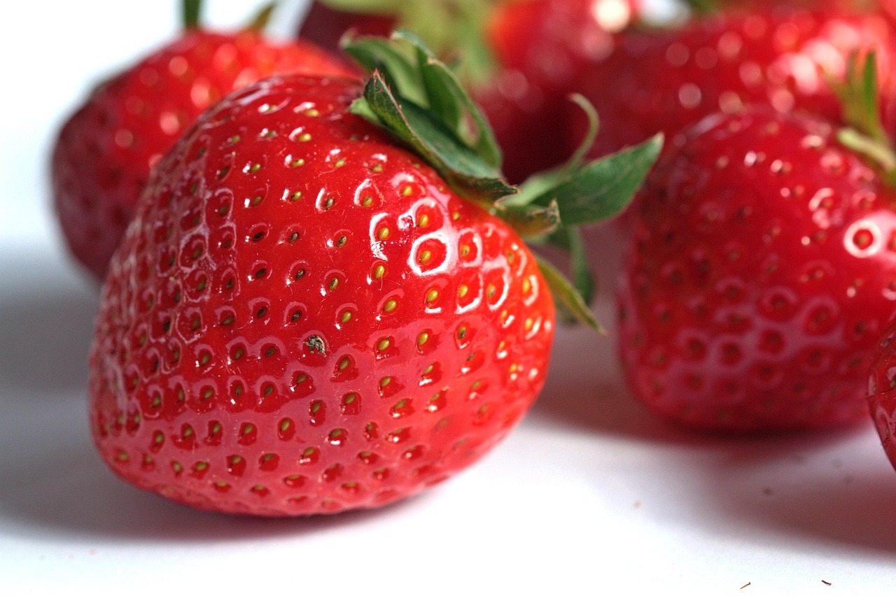 Morangos vermelhos frescos e brilhantes representando alimentos benéficos para o coração.