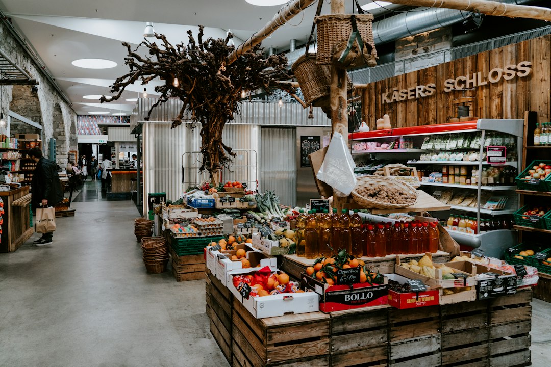 Bancas de mercado com frutas e legumes frescos dispostos em caixotes de madeira.