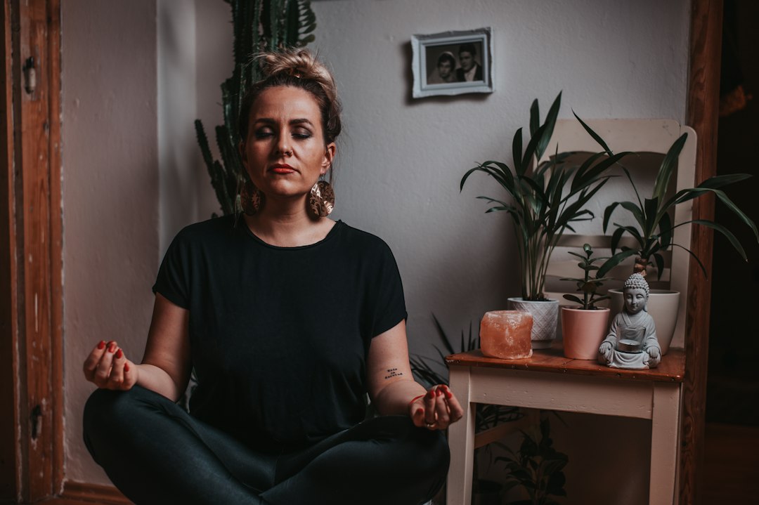 Mulher praticando meditação e respiração consciente com os olhos fechados para relaxar