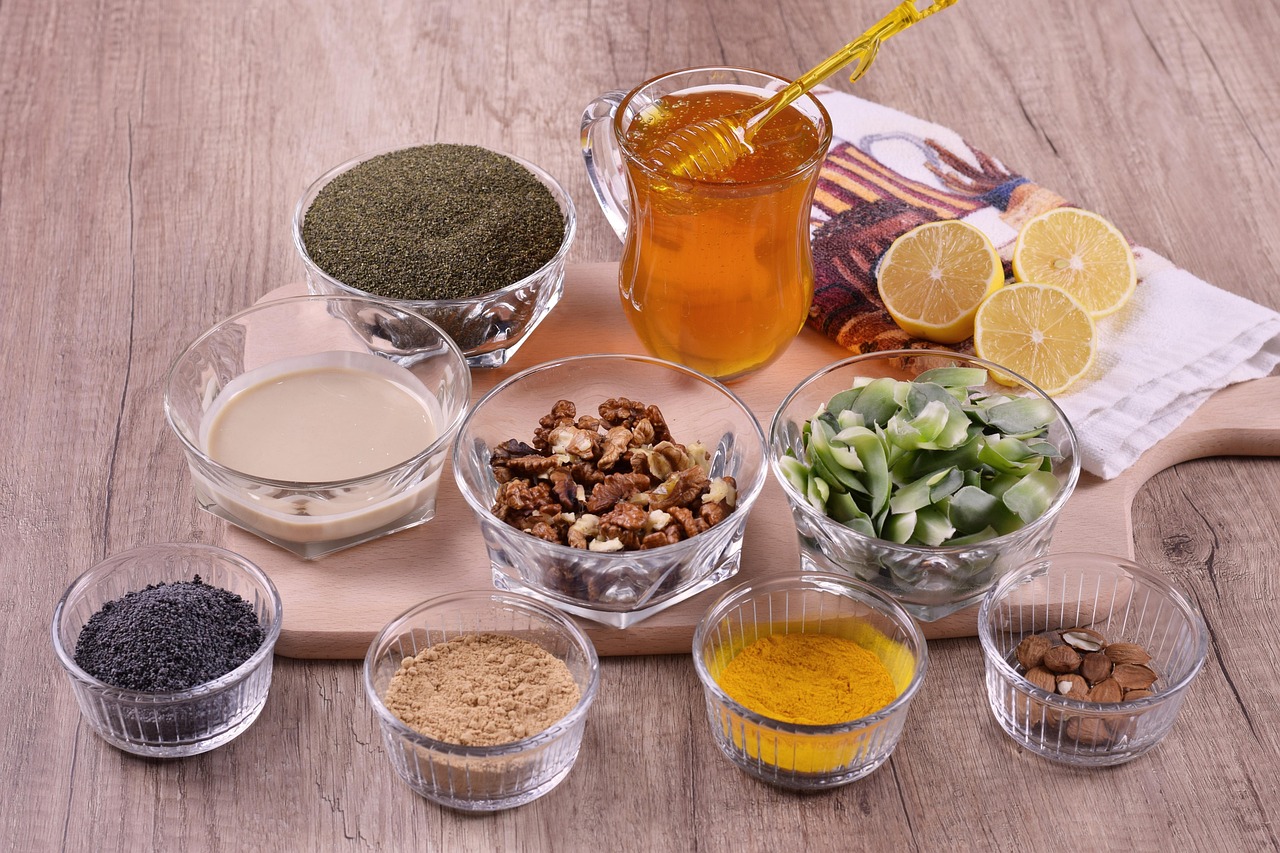 Recipientes com nozes, amêndoas, sementes e ingredientes naturais sobre uma mesa de madeira.